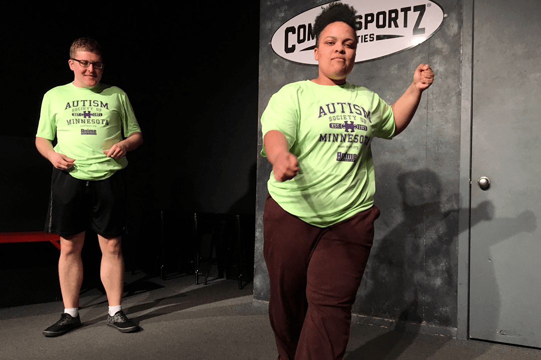 Adults on stage in front of ComedySportz sign