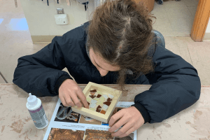 A young girl places tiles into a mosaic