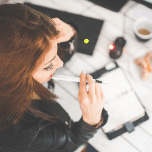 An overhead shot of a woman writing in a planner